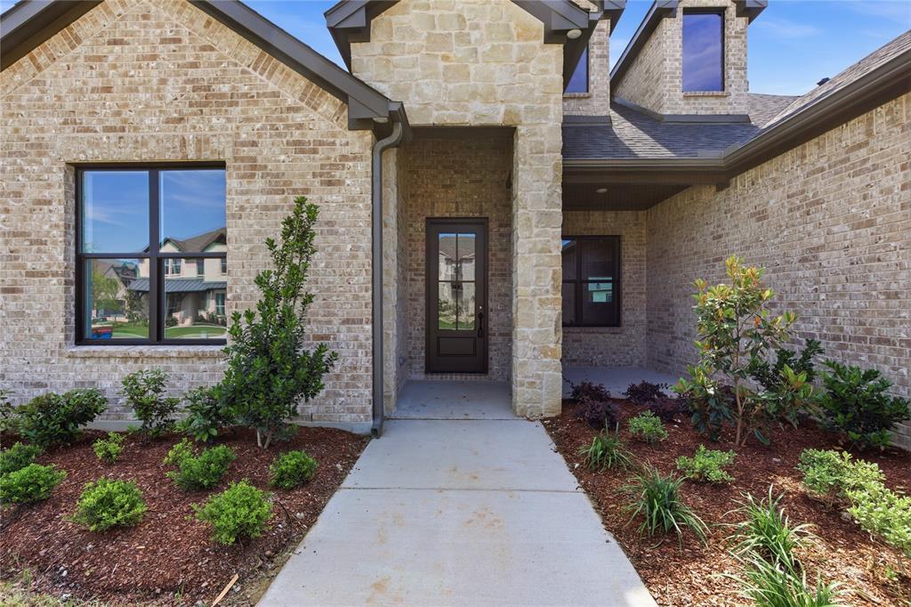 709 Anne Road Van Alstyne, TX 75495 - Photo 2 of 28 Brick and stone veneer exterior with dark-framed windows