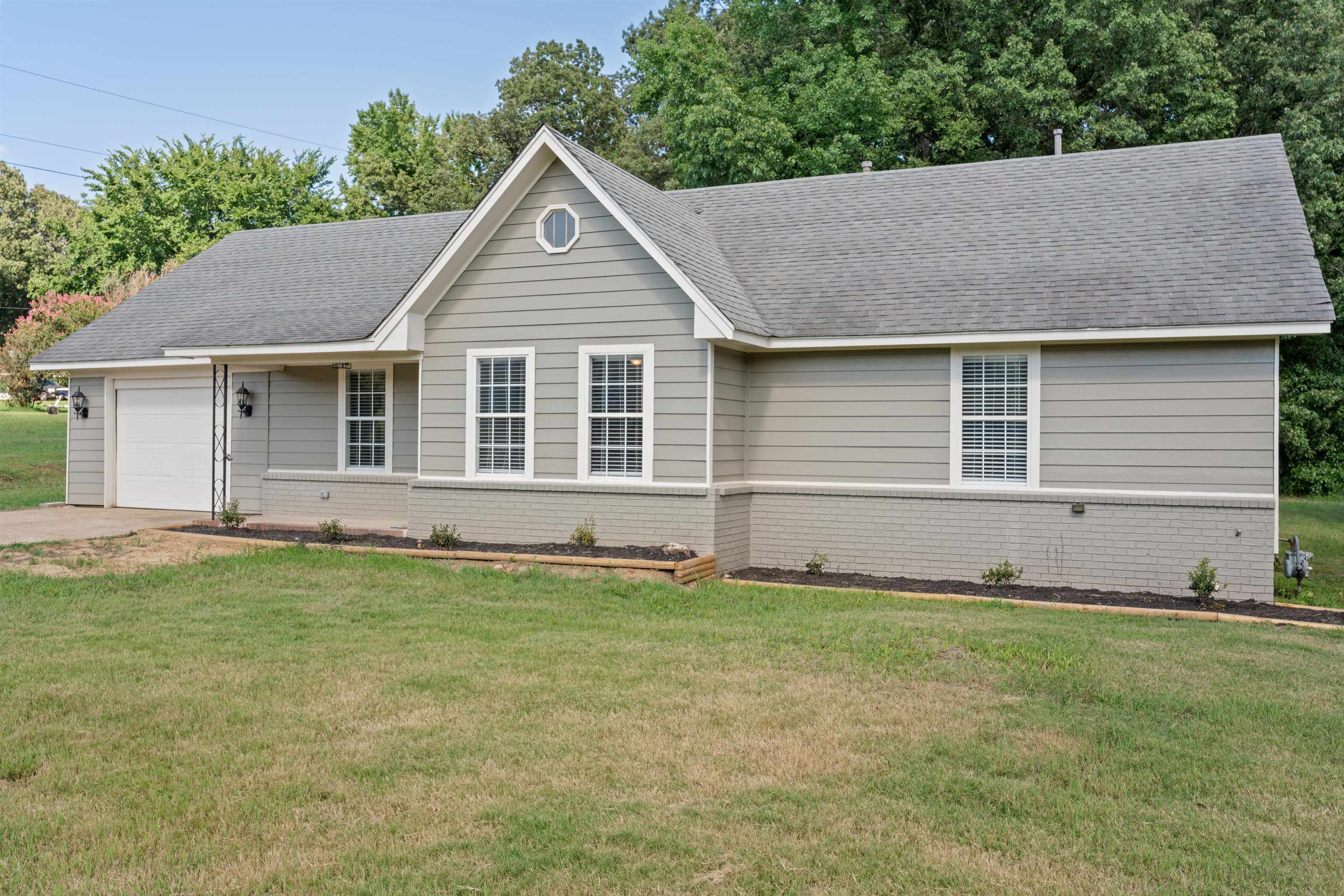 3282 Sunnyside Road Brighton, TN 38011 - Photo 2 of 24 Ranch-style house featuring a garage and a front lawn