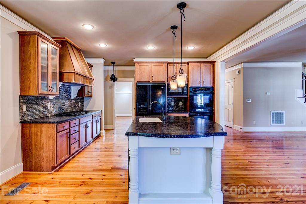 797 Shady Grove Crossing Fort Mill, SC 29708 - Photo 11 of 35 a kitchen with stainless steel appliances granite countertop a sink a stove and a wooden cabinets