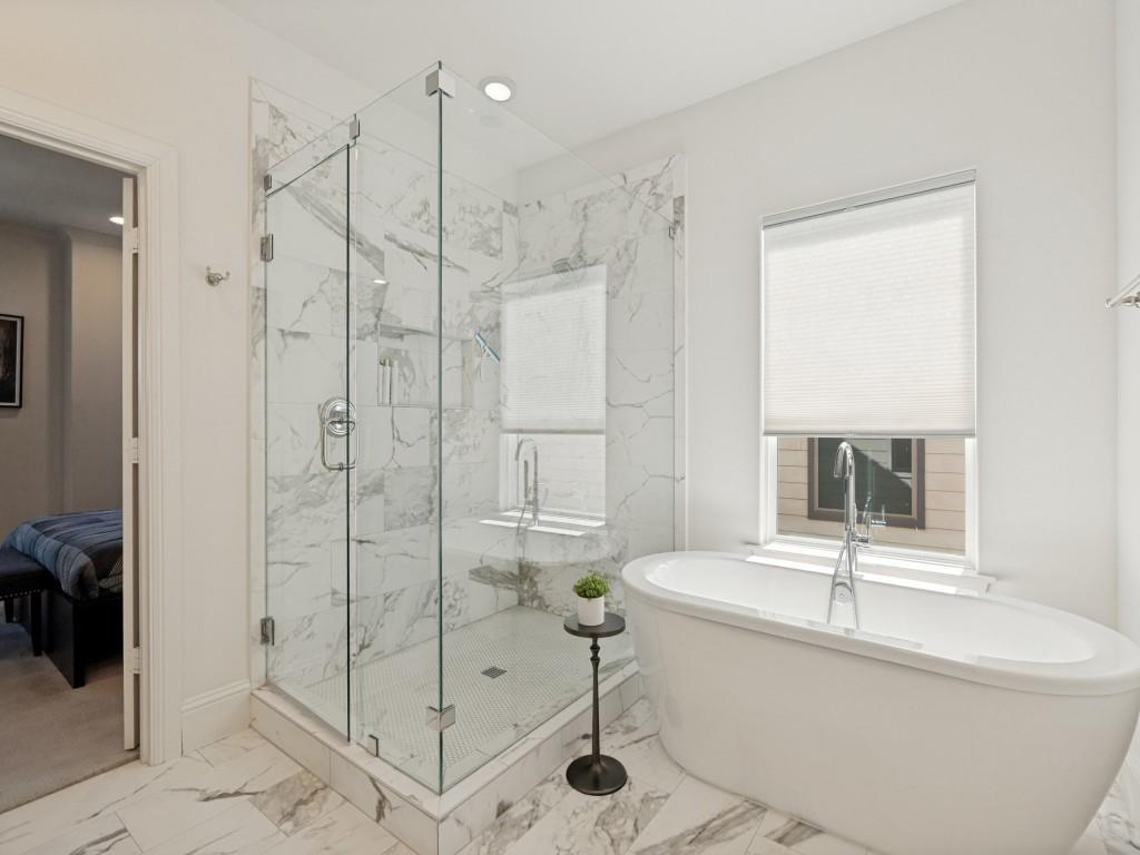 732 West 7th Street Dallas, TX 75208 - Photo 14 of 25 Luxurious bathroom featuring a spacious walk-in shower with frameless glass enclosure and marble-look tile surround