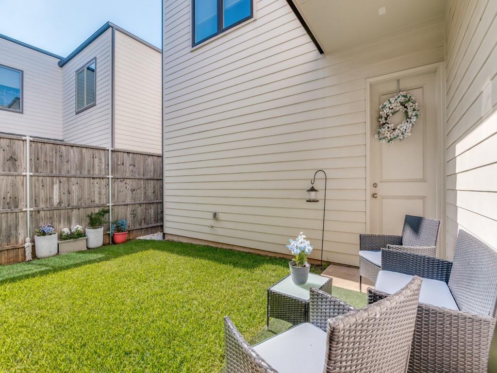 732 West 7th Street Dallas, TX 75208 - Photo 23 of 25 Private fenced backyard with lush green lawn, wood privacy fencing, and a paved patio area