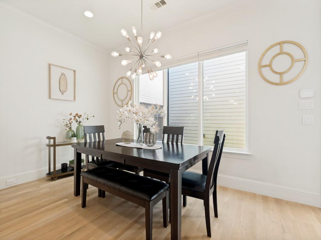 732 West 7th Street Dallas, TX 75208 - Photo 6 of 25 Dining area featuring a contemporary chandelier, light wood-finish flooring, and a large window with privacy blinds