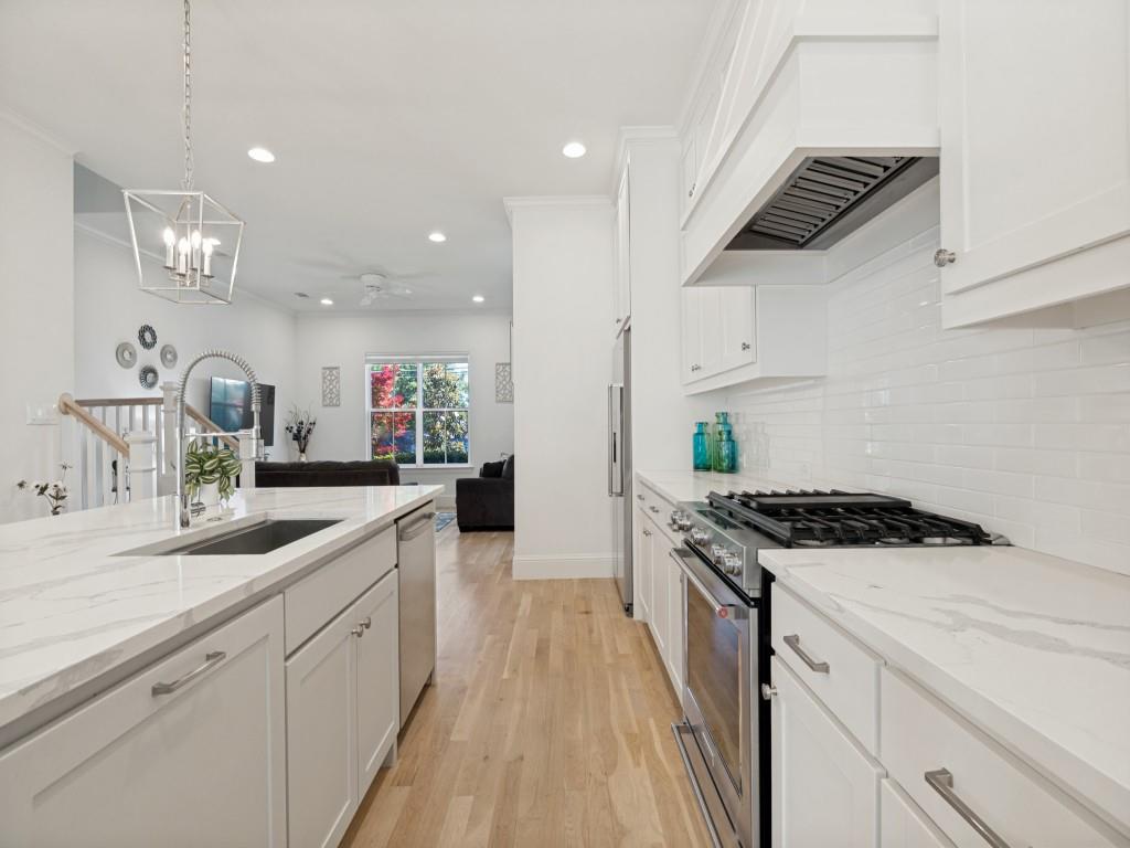 732 West 7th Street Dallas, TX 75208 - Photo 10 of 25 Modern kitchen featuring light wood-finish flooring, white cabinetry, and a subway tile backsplash