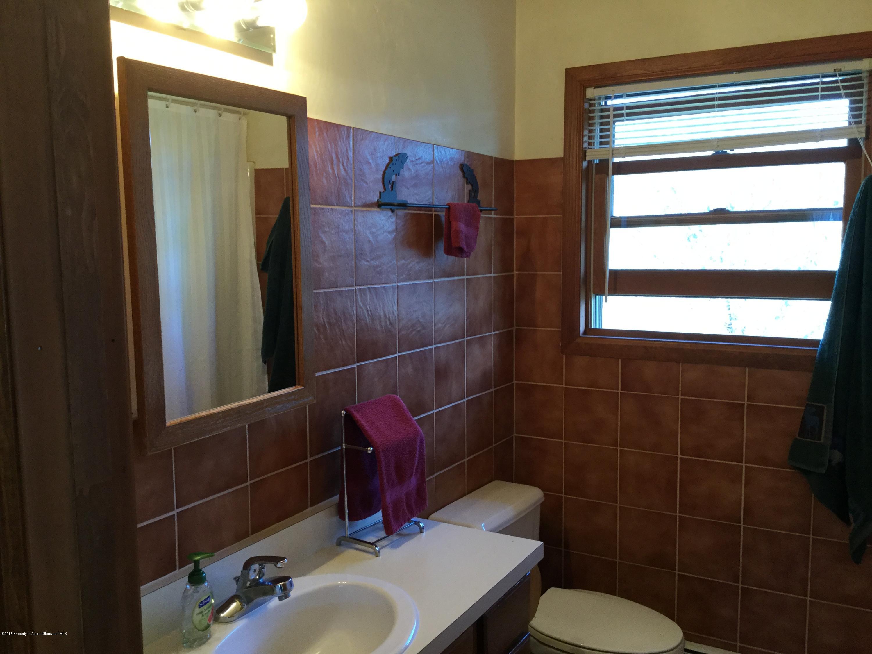 4112 County Road 226 Rifle, CO 81650 - Photo 9 of 34 a bathroom with a sink toilet and mirror
