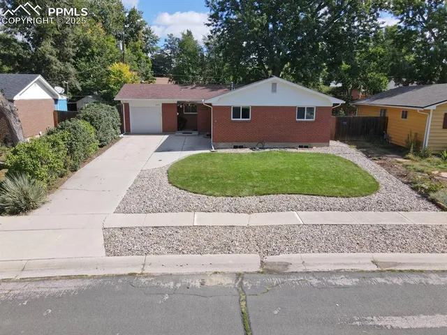 a front view of a house with a garden and garage