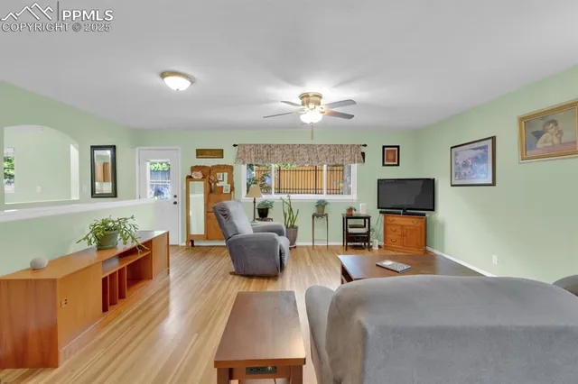 a kitchen with stainless steel appliances granite countertop a stove top oven a sink dishwasher a refrigerator and a dining table with wooden floor