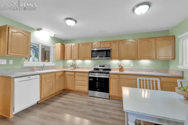 a kitchen with stainless steel appliances granite countertop a stove a sink and a microwave