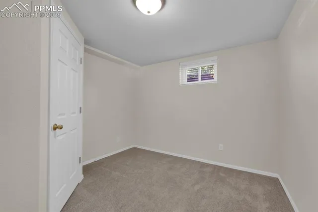 a view of an empty room with closet and a bathroom