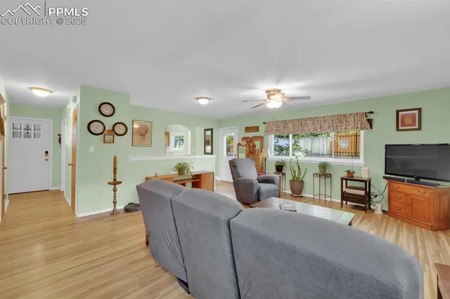 a living room with furniture and a wooden floor