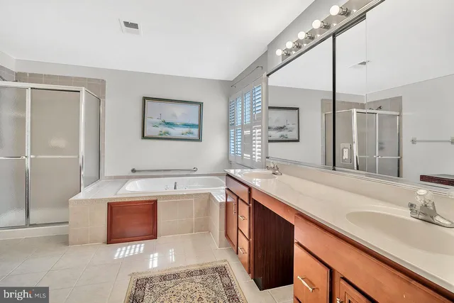 a spacious bathroom with a bathtub sink and mirror