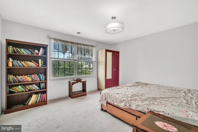 a bedroom with a bed and a book shelf