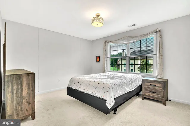 a bed sitting in a bedroom next to a window