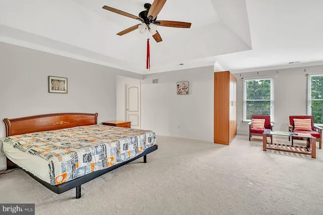 a bedroom with a bed a couch and a chandelier