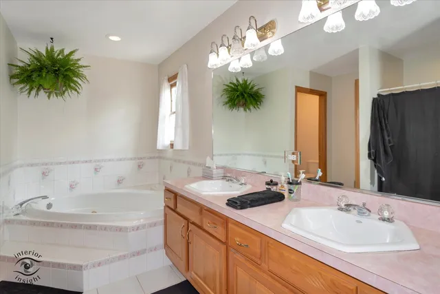 a bathroom with a tub sink and mirror