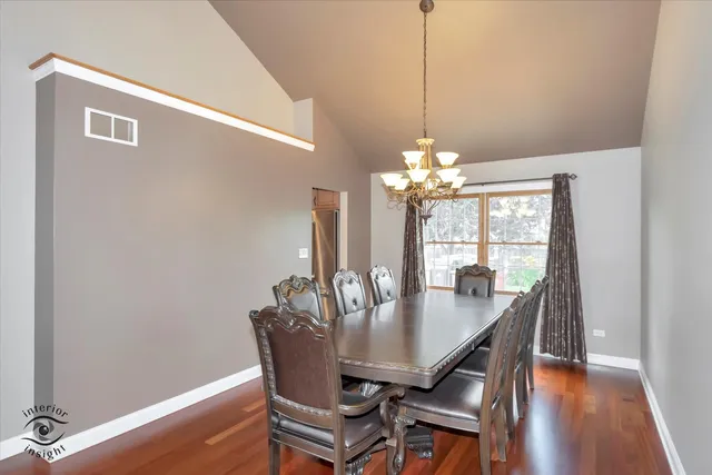 a dining room with furniture a chandelier and wooden floor