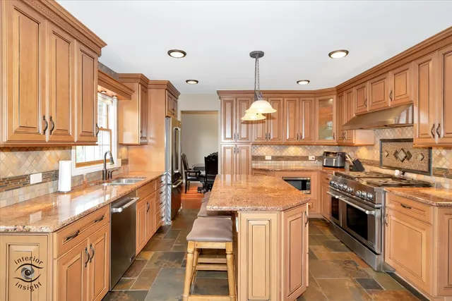a kitchen with stainless steel appliances granite countertop a stove a sink dishwasher and a refrigerator