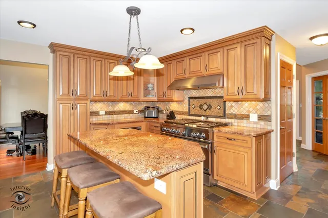 a kitchen with stainless steel appliances granite countertop a oven a stove and a refrigerator