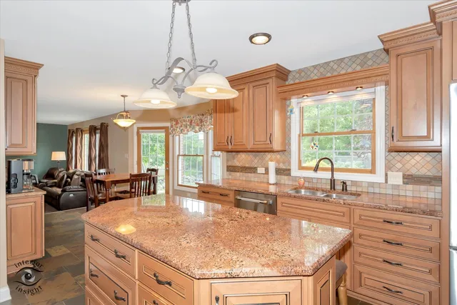 a kitchen with granite countertop a sink a counter space appliances and cabinets