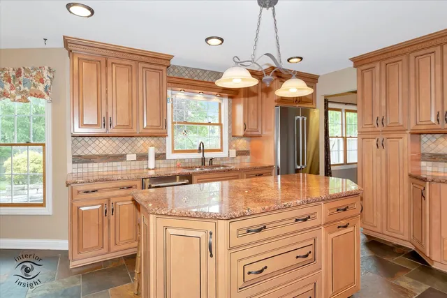a kitchen with granite countertop a sink appliances cabinets and a large window