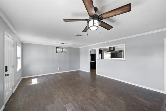 a view of an empty room with wooden floor