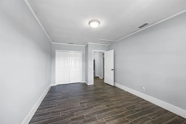 a view of an empty room with wooden floor