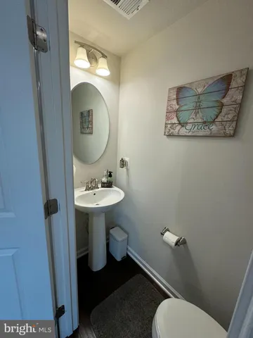 a bathroom with a toilet a sink and mirror
