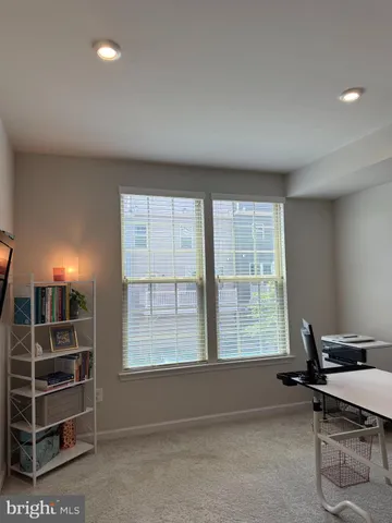 a view of a workspace with furniture and a window