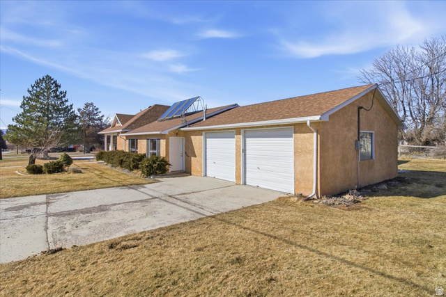 217 East 400 South Spring City, UT 84662 - Photo 59 of 71 View of front of property featuring a front lawn, concrete driveway, stucco siding, and an attached garage