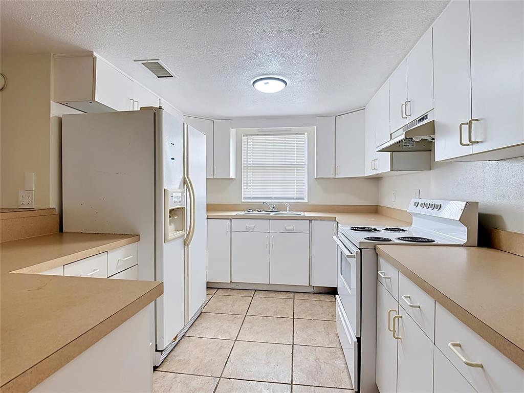 7925 Lake Mabel Loop Road Lake Wales, FL 33898 - Photo 67 of 97 a kitchen with a stove a sink and a refrigerator