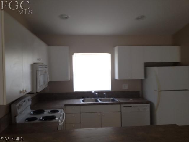 4440 28th Street Southwest Lehigh Acres, FL 33973 - Photo 4 of 4 a kitchen with a sink and a stove top oven