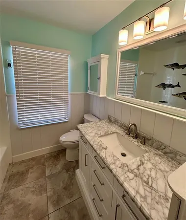 a bathroom with a sink a toilet and a mirror