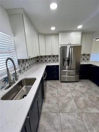 a kitchen with granite countertop a refrigerator and a sink