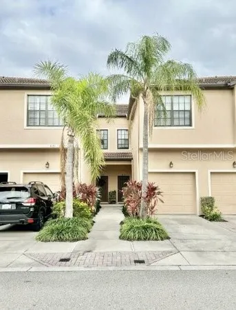 a front view of a house with a garden and parking