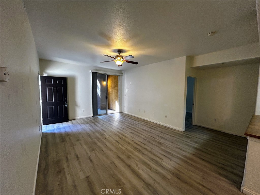 24909 Madison, Unit 111 Murrieta, CA 92562 - Photo 4 of 25 a view of an empty room with wooden floor and a window