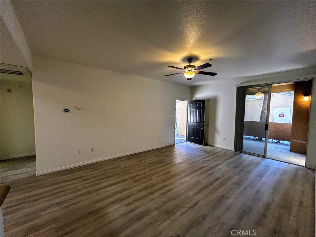 24909 Madison, Unit 111 Murrieta, CA 92562 - Photo 5 of 25 a view of an empty room with a window and wooden floor
