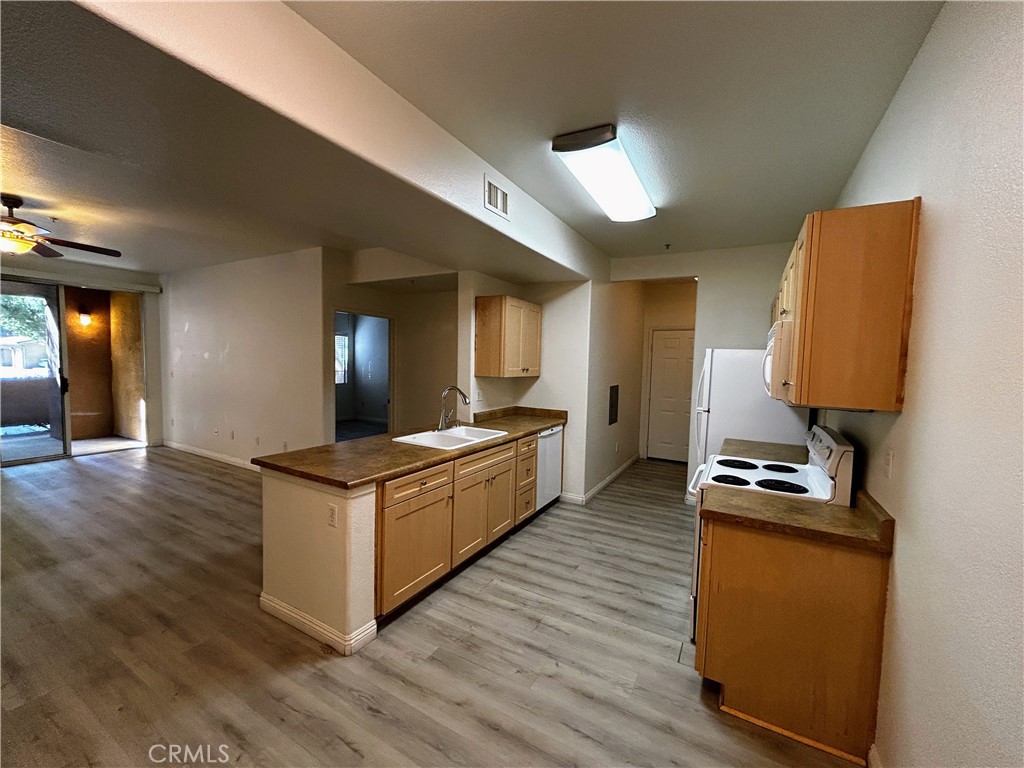 24909 Madison, Unit 111 Murrieta, CA 92562 - Photo 6 of 25 a kitchen with kitchen island granite countertop a stove and a refrigerator