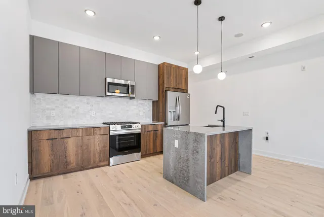 a kitchen with stainless steel appliances granite countertop a sink a stove and a refrigerator