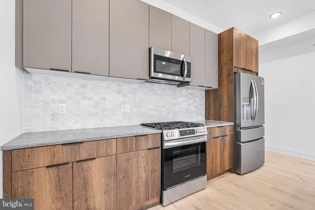 a kitchen with stainless steel appliances granite countertop a refrigerator stove and microwave