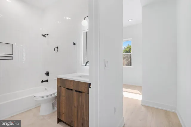 a bathroom with a bathtub sink vanity mirror and toilet