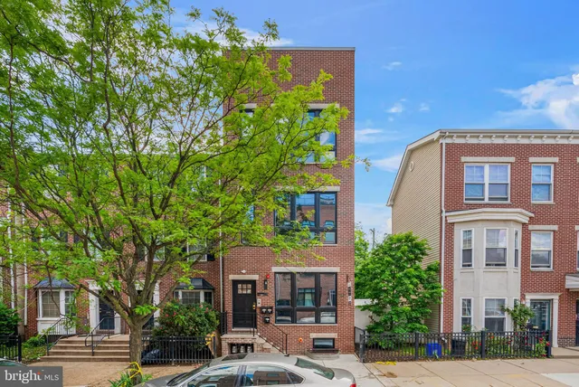 a front view of a residential apartment building with a yard