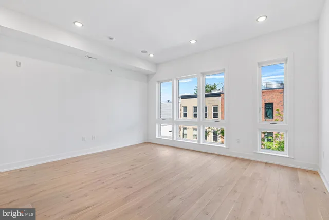 an empty room with windows and cabinet