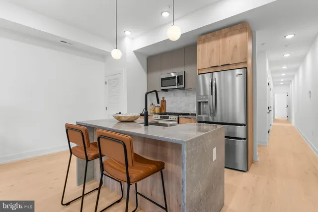 a kitchen with kitchen island a sink appliances and cabinets