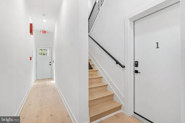 a view of a hallway with wooden floor and entryway
