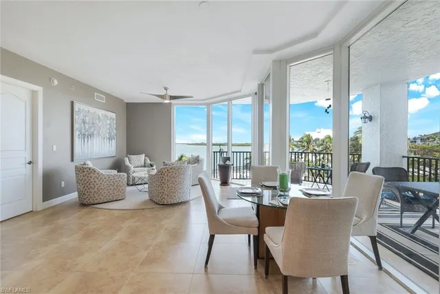 a dining room with furniture and large windows