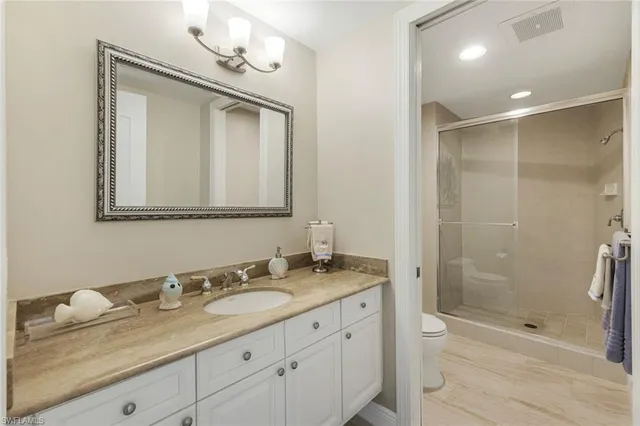 a bathroom with a granite countertop sink a mirror and a shower