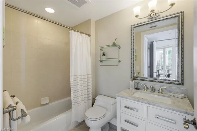 a bathroom with a granite countertop sink a toilet and shower