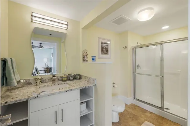 a bathroom with a granite countertop sink toilet and shower