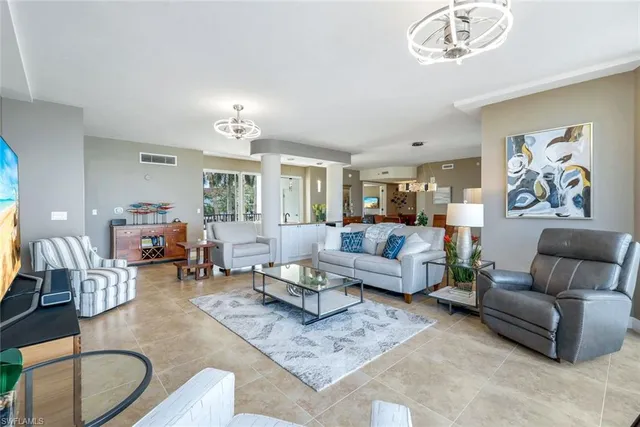 a living room with furniture and a chandelier