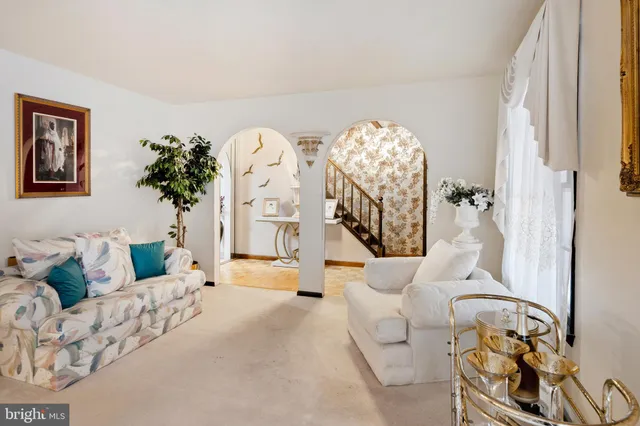 a front view of a house with a yard covered with snow and trees