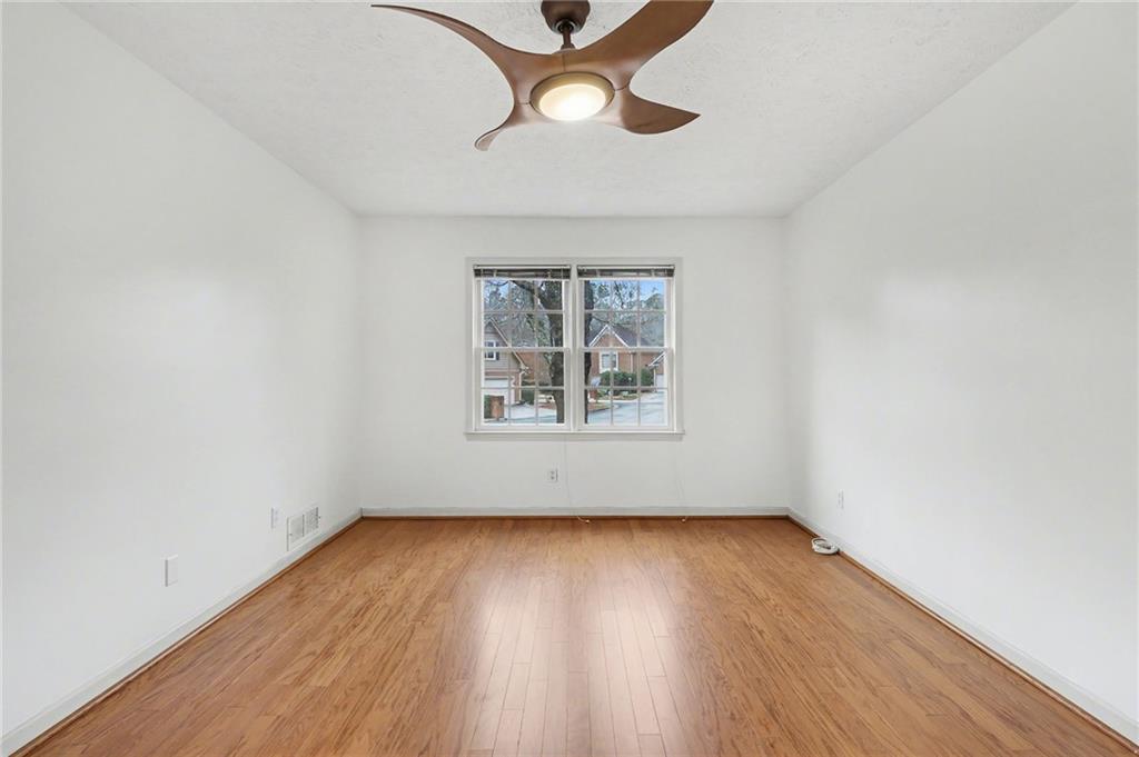 2981 Wilsons Crossing Court Decatur, GA 30033 - Photo 16 of 24 an empty room with wooden floor chandelier fan and windows